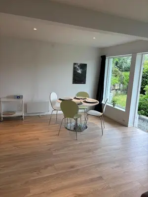 a dining room with a table and chairs and a window at Large and bright apartment, perfect base in autumn in Ålesund