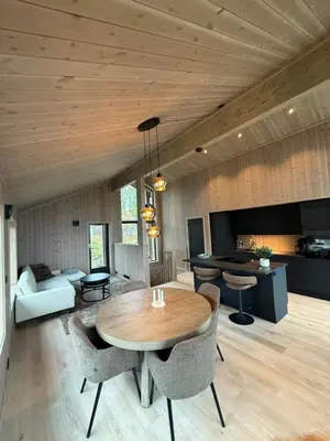 a kitchen and living room with a table and chairs at Exclusive cabin with sauna and mountain view in Geilo in Hol