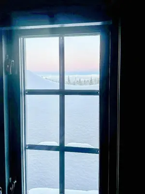 a window with a view of the snow outside at Log Cabin With Views Of Jotunheimen in Øyer