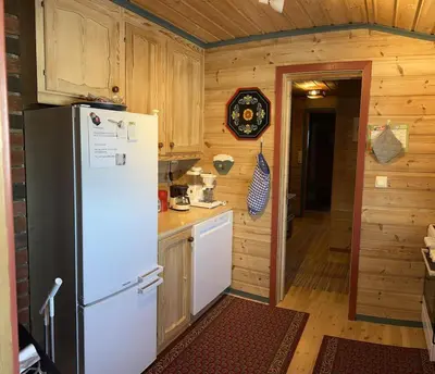 a kitchen with a white refrigerator in a room at Very central and by the lake Sjusjøen in Ringsaker
