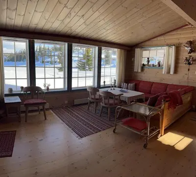 a living room with a red couch and a table at Very central and by the lake Sjusjøen in Ringsaker