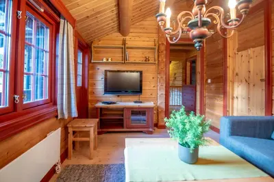 a living room with a tv and a blue couch at Lisetra 716B in Trysil