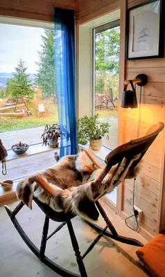 a dog laying on a chair in a room with a window at Family Cabin With Views Over Hadeland in Lunner