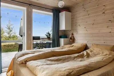 two beds in a room with a wooden wall at Family Cabin With Views Over Hadeland in Lunner