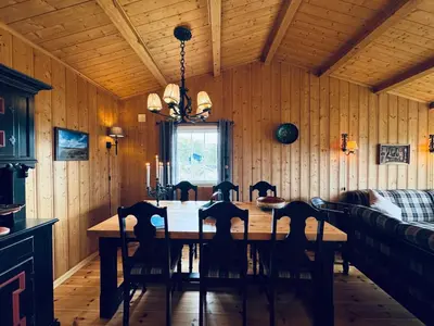 a dining room with a wooden table and chairs at Fjellro-Geilo Cabin Retreat in Geilo