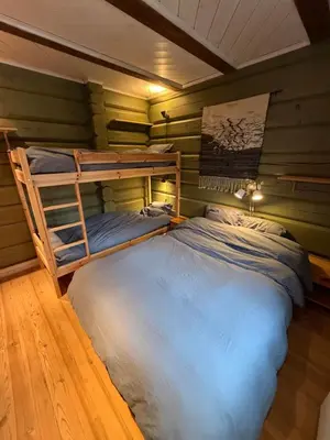 a bedroom with a bunk bed in a room with green walls at Log cabin at Hafjell in Øyer