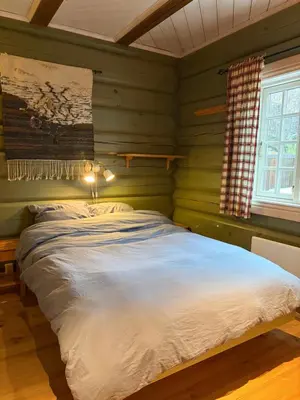 a bedroom with green walls and a large bed at Log cabin at Hafjell in Øyer