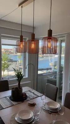 a dining room with a table with three lights at Sentrumsnær leilighet Bergen in Bergen