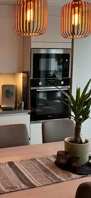 a kitchen with a table with a microwave and a dining room at Sentrumsnær leilighet Bergen in Bergen