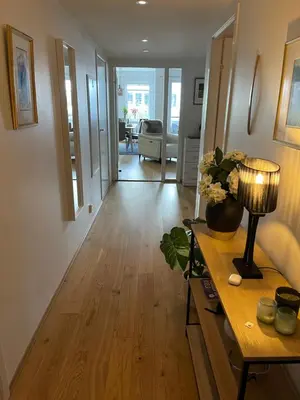 a living room with a table with a lamp on it at Sentrumsnær leilighet Bergen in Bergen