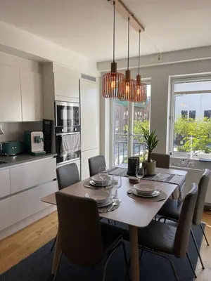 a kitchen and dining room with a table and chairs at Sentrumsnær leilighet Bergen in Bergen