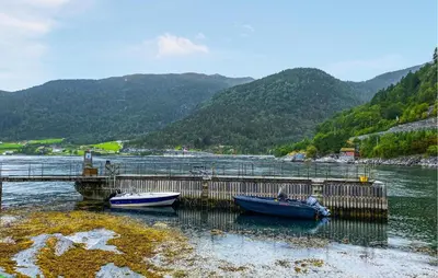 two boats are docked at a dock in the water at Gorgeous Home In Lavik With House Sea View in Lavik
