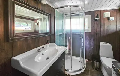 a bathroom with a sink and a glass shower at 2 Bedroom Nice Home In Noresund in Noresund