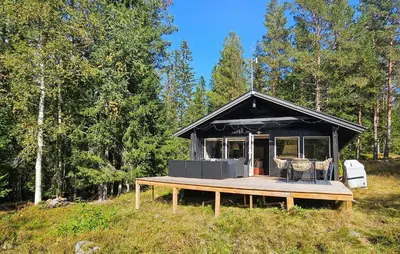 a black house with a deck in a field at 2 Bedroom Nice Home In Noresund in Noresund