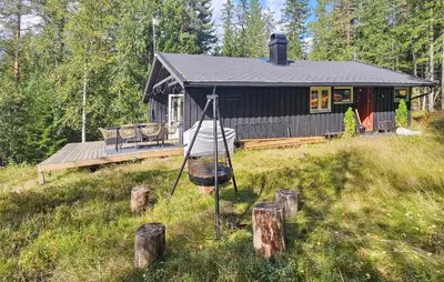 a black cabin with a porch and a deck at 2 Bedroom Nice Home In Noresund in Noresund