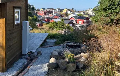 a backyard with a rock garden next to a house at Lovely Home In Mausund With Wifi in Bogøyvær