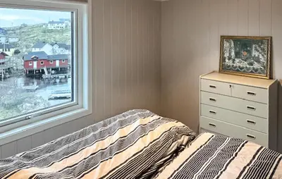a bedroom with a bed and a window at Lovely Home In Mausund With Wifi in Bogøyvær
