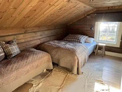 a bedroom with two beds in a wooden cabin at ØRNENIPA LODGE- flott hytte med 6 sov, 2 bad og beste beliggenhet in Gaustablikk