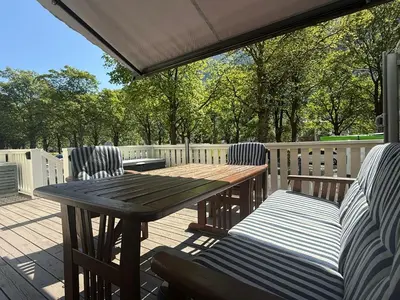 a wooden table and chairs on a deck at Tveitopark Apartments B in Rjukan