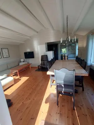 a large living room with a large wooden table and chairs at Mountain view cabin in Torvik