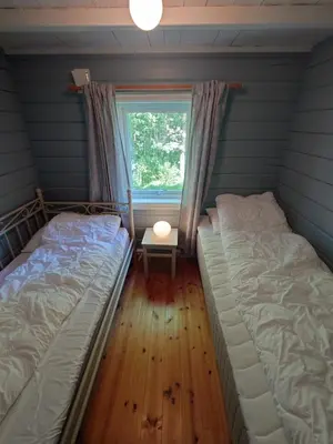 two beds in a room with a window at Mountain view cabin in Torvik