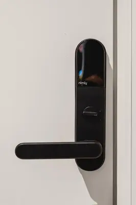 a black door handle on a white door at Trolltunga Stay in Odda