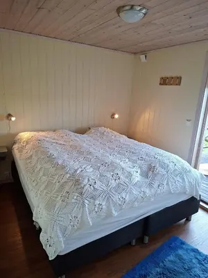 a bedroom with a bed with a white comforter at Moderne hytte på Tingvoll nær sjø og turterreng in Tingvoll