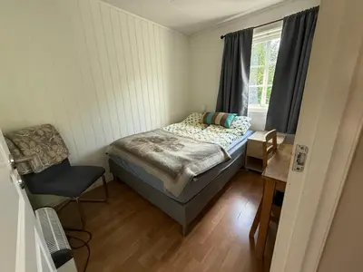 a small bedroom with a bed and a chair at Vistdal Panoramic View in Myklebostad