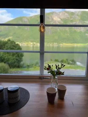 a table with three cups and a vase with flowers on it at Vistdal Panoramic View in Myklebostad