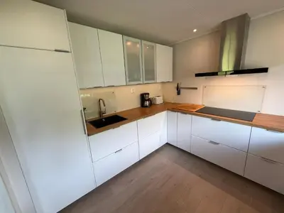 a kitchen with white cabinets and a sink at Vistdal Panoramic View in Myklebostad