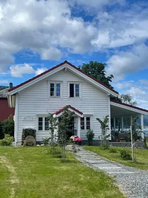 a white house with a red at Charming house by the fjord in Utvik