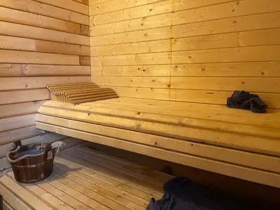 a wooden sauna with a trash can and a bucket at Charming house by the fjord in Utvik