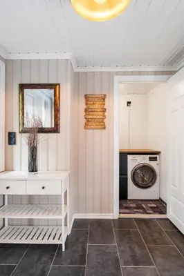a laundry room with a washing machine and a mirror at Lingåsen Panorama! in Valldal