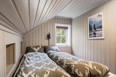 a bedroom with a bed in the corner of a room at Lingåsen Panorama! in Valldal