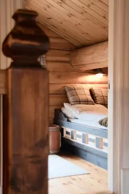 a bedroom with a bed in a wooden cabin at Nydelig hyttetun på Torpoåsen in Torpo