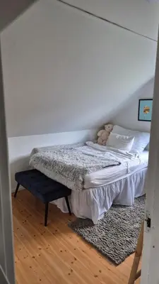 a bedroom with a bed and a blue stool at Charming family house with beautiful views! in Askøy