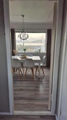 a dining room with a table and chairs and a chandelier at Charming family house with beautiful views! in Askøy