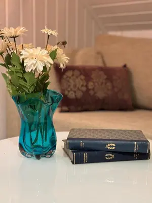 a book and a vase with flowers and a book at 3 soveroms leilighet-komfort og stil -perfekt for ferie og jobb in Gjøvik