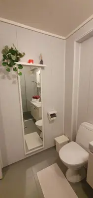 a white bathroom with a toilet and a sink at Fotlandsvåg Guest Apartment in Bernes