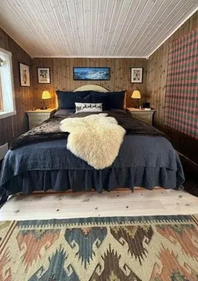 a bedroom with a large bed with two night stands at Timber Cabin With Wood-Fired Hot Tub In Trysil in Trysil