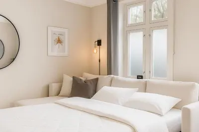 a white living room with a white couch and window at Apartment Bergen Center - Quiet Gem - Norwegians Minimum Age 25 in Bergen