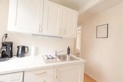 a kitchen with white cabinets and a sink at Apartment Bergen Center - Quiet Gem - Norwegians Minimum Age 25 in Bergen