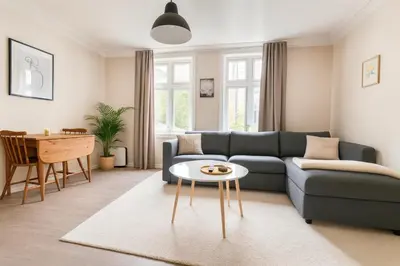 a living room with a blue couch and a table at Bergen City Retreat - Steps from Bryggen - Norwegians Minimum Age 25 in Bergen