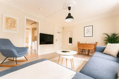 a living room with a blue couch and a table at Bergen City Retreat - Steps from Bryggen - Norwegians Minimum Age 25 in Bergen