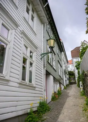 a white building with a street light next to it at Central & Quiet by Bryggen - Norwegians Minimum Age 25 in Bergen