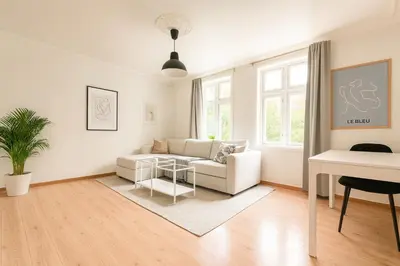 a living room with a white couch and a table at Central & Quiet by Bryggen - Norwegians Minimum Age 25 in Bergen