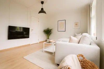 a living room with a white couch and a table at Central & Quiet by Bryggen - Norwegians Minimum Age 25 in Bergen