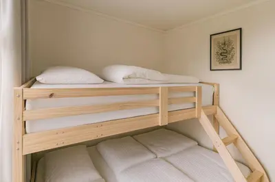 two bunk beds with white pillows on them in a room at Delightful Bryggen Apartment - Norwegians Minimum Age 25 in Bergen