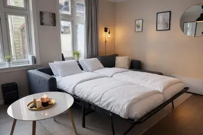 a large bed in a living room with a table at Trio Central in centre - Norwegians Minimum Age 25 in Bergen
