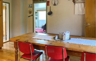 a dining room table with four red chairs at Lovely Home In Fiksdalen in Fiksdal